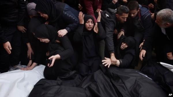 Palestinians mourn relatives killed in the Israeli bombardment of the Gaza Strip outside a morgue in Khan Younis, Dec. 20, 2023.